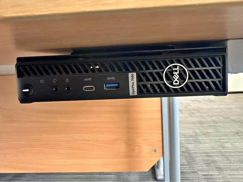 A Dell OptiPlex mounted under a desk